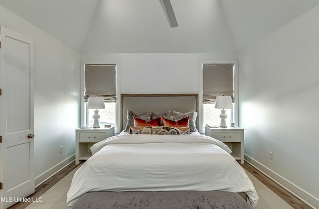 bedroom featuring multiple windows, wood-type flooring, and vaulted ceiling