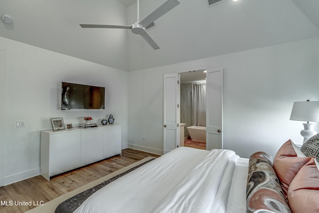 bedroom with hardwood / wood-style flooring, lofted ceiling, connected bathroom, and ceiling fan