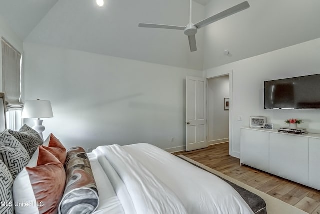 bedroom with ceiling fan, lofted ceiling, and hardwood / wood-style floors