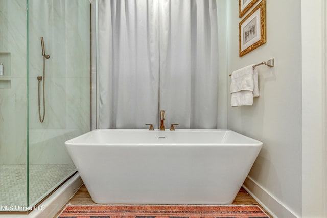 bathroom with plus walk in shower and hardwood / wood-style floors