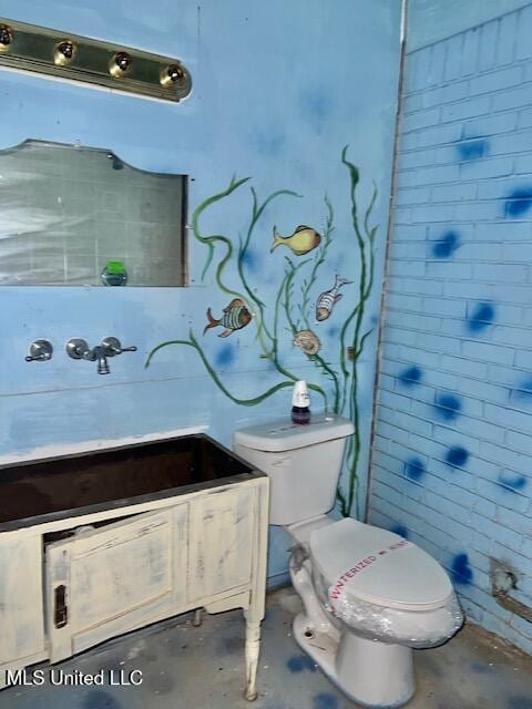 bathroom featuring concrete floors and toilet