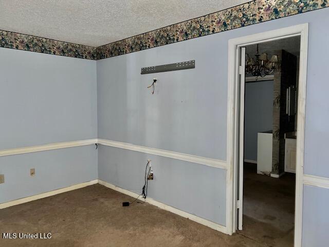 carpeted spare room with a textured ceiling