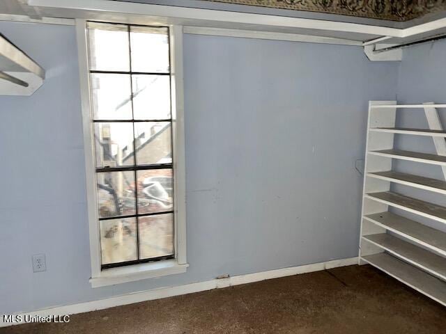 walk in closet with dark carpet