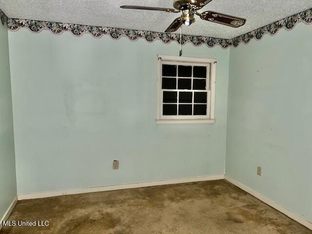 empty room featuring ceiling fan, a textured ceiling, and carpet flooring