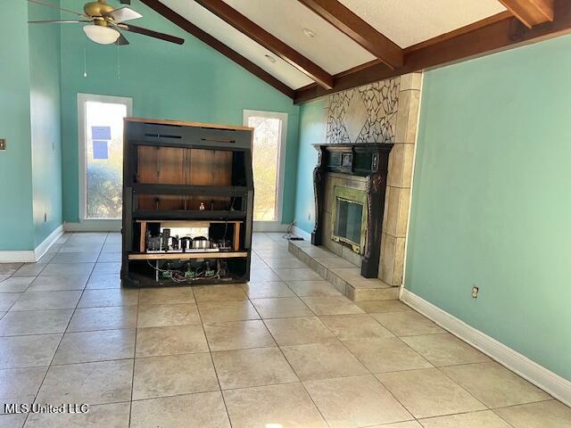 unfurnished living room featuring light tile patterned flooring, ceiling fan, beam ceiling, and high vaulted ceiling