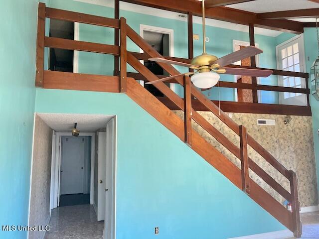 staircase featuring ceiling fan