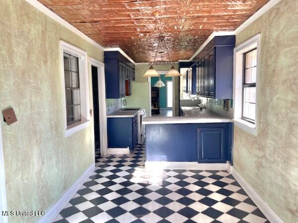 kitchen with crown molding, brick ceiling, blue cabinets, and kitchen peninsula