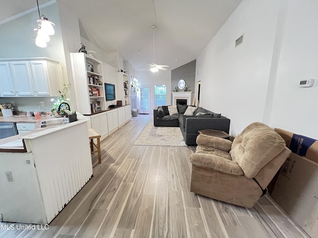9929 Kahana St, Diamondhead, MS 39525 - living area featuring high vaulted ceiling, ceiling fan, light wood finished floors, and a fireplace