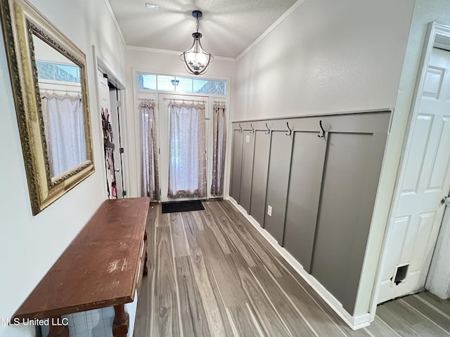 9929 Kahana St, Diamondhead, MS 39525 - entryway with wood finished floors, ornamental molding, wainscoting, and a chandelier