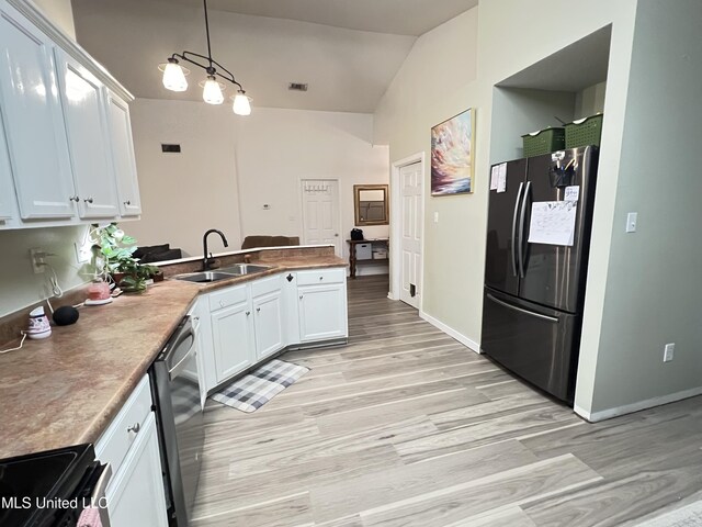 9929 Kahana St, Diamondhead, MS 39525 - kitchen with stainless steel appliances, a peninsula, light wood finished floors, lofted ceiling, and white cabinetry