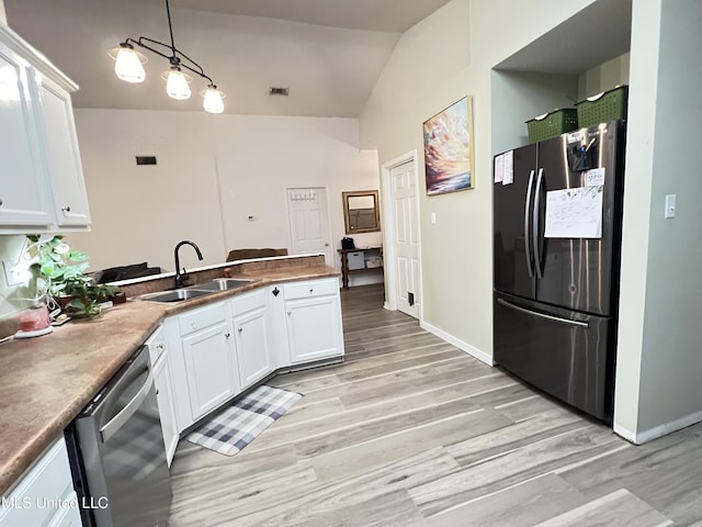 9929 Kahana St, Diamondhead, MS 39525 - kitchen featuring stainless steel appliances, white cabinetry, a peninsula, vaulted ceiling, and hanging light fixtures