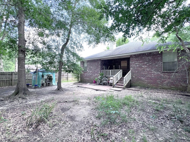 9929 Kahana St, Diamondhead, MS 39525 - back of house featuring brick siding, a chimney, and a shingled roof