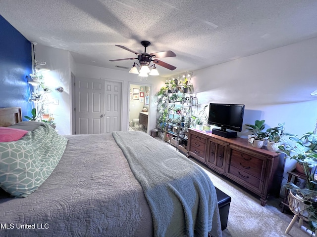9929 Kahana St, Diamondhead, MS 39525 - bedroom with a textured ceiling, carpet floors, ceiling fan, and ensuite bath