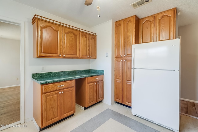 kitchen featuring built in desk, white fridge, and ceiling fan