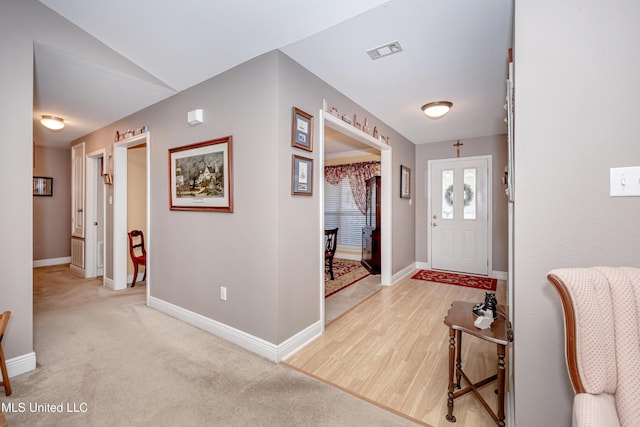 foyer entrance featuring visible vents, baseboards, and light wood-style floors