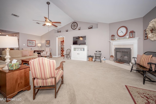 living area featuring a tiled fireplace, visible vents, light colored carpet, and a ceiling fan