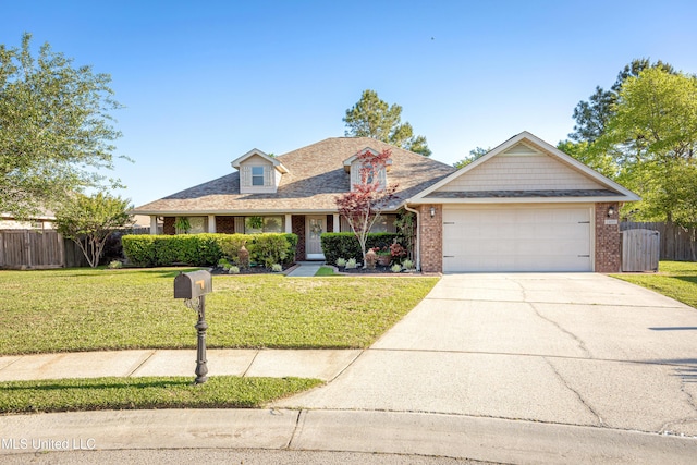 traditional home featuring a front yard, an attached garage, fence, and brick siding