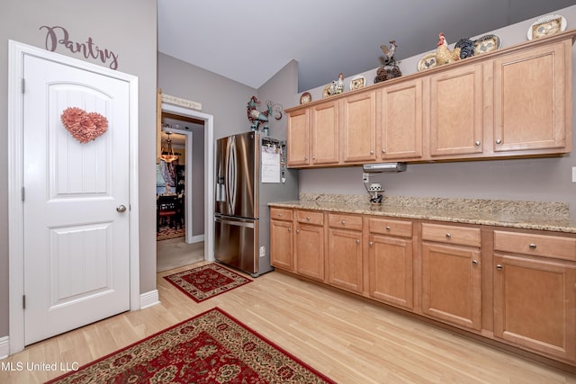 kitchen featuring light wood-style floors, light stone counters, and stainless steel fridge with ice dispenser