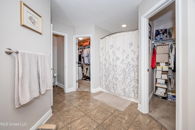 full bathroom featuring a spacious closet, baseboards, recessed lighting, and curtained shower