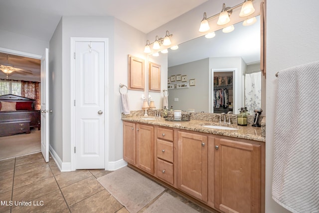 ensuite bathroom featuring double vanity, a sink, tile patterned flooring, and connected bathroom
