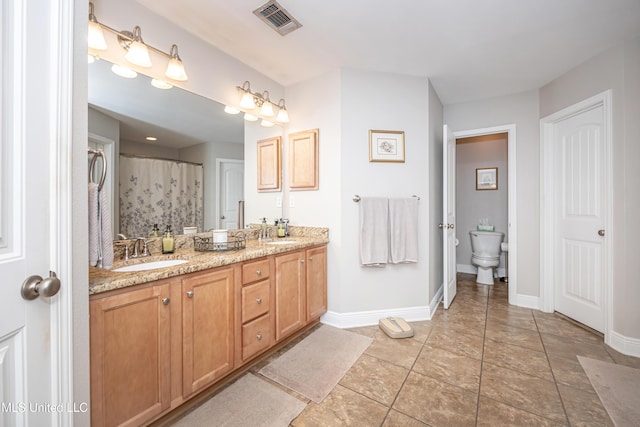 full bath with toilet, double vanity, a sink, and visible vents