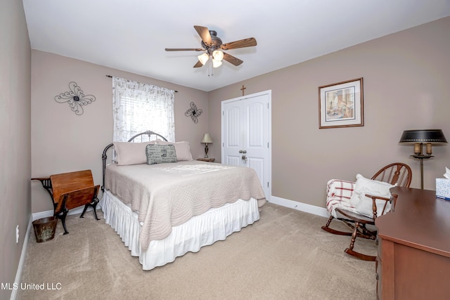 bedroom with a closet, baseboards, ceiling fan, and light carpet