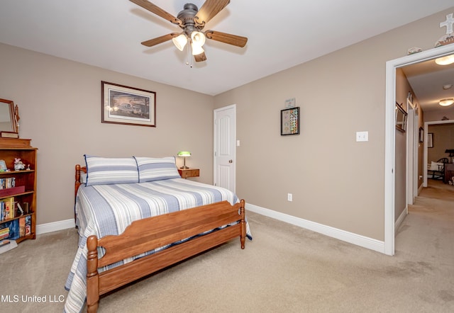 bedroom featuring light colored carpet, baseboards, and a ceiling fan