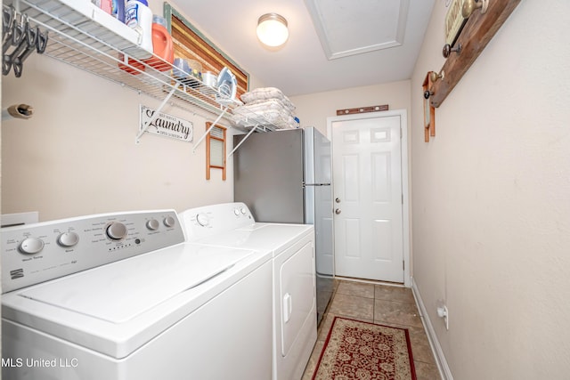 washroom featuring washer and clothes dryer, laundry area, baseboards, and light tile patterned flooring