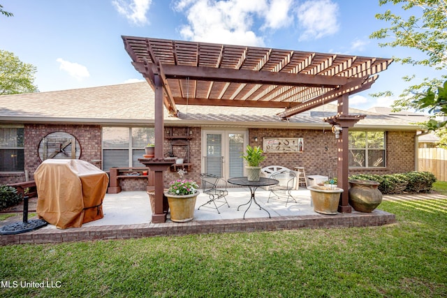 back of property featuring a lawn, a pergola, roof with shingles, and brick siding