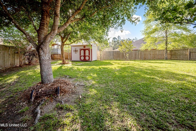 view of yard featuring an outbuilding, a shed, and a fenced backyard