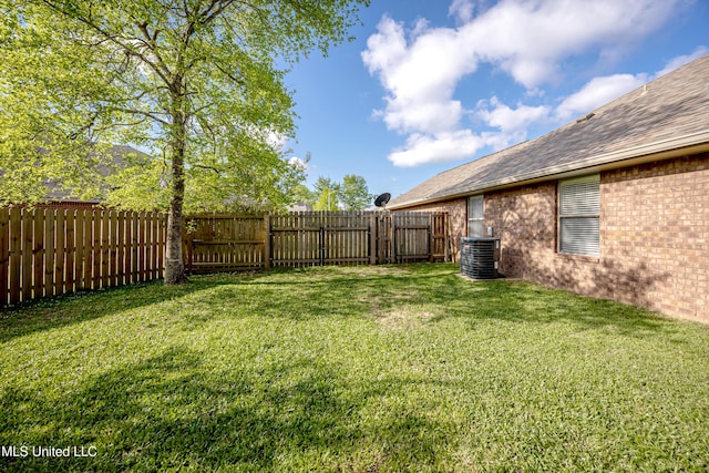 view of yard with a fenced backyard and central air condition unit