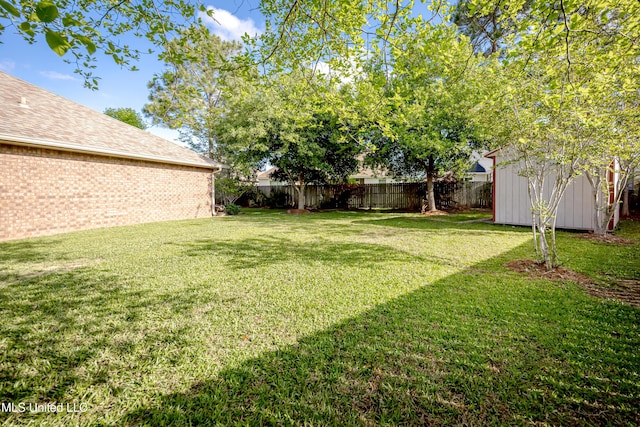 view of yard featuring a shed, a fenced backyard, and an outdoor structure