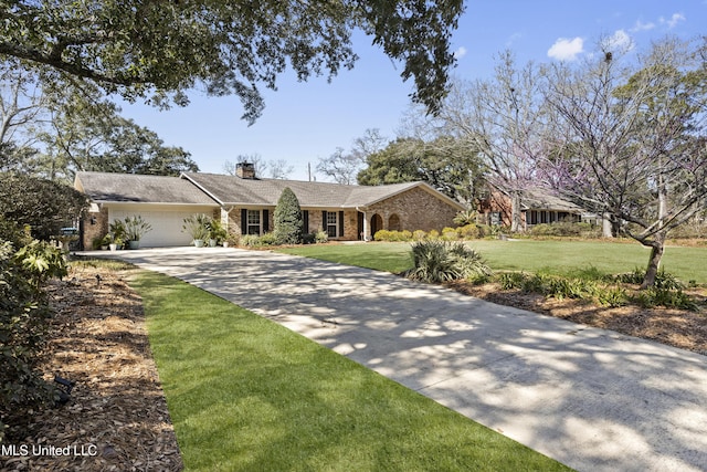 ranch-style house featuring an attached garage, a chimney, concrete driveway, and a front yard