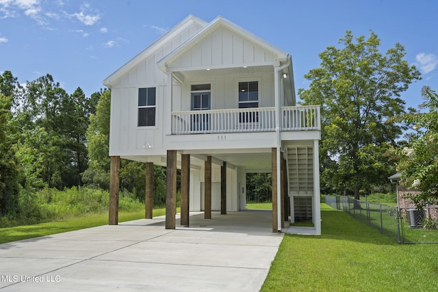 raised beach house featuring a front yard and a carport