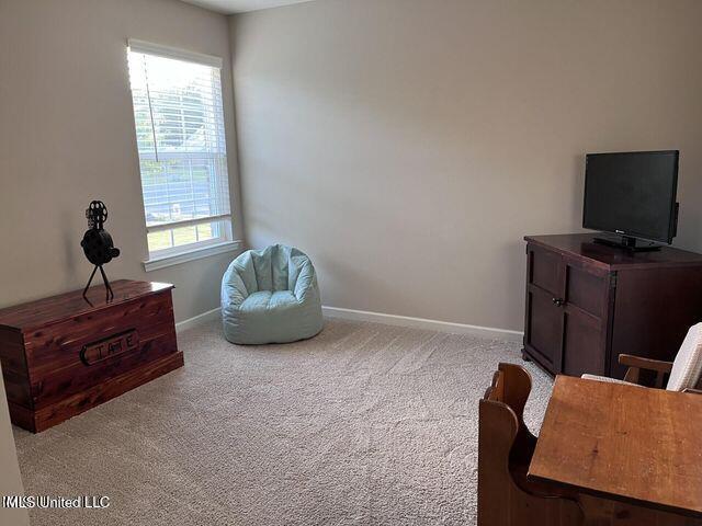 sitting room featuring carpet flooring and baseboards