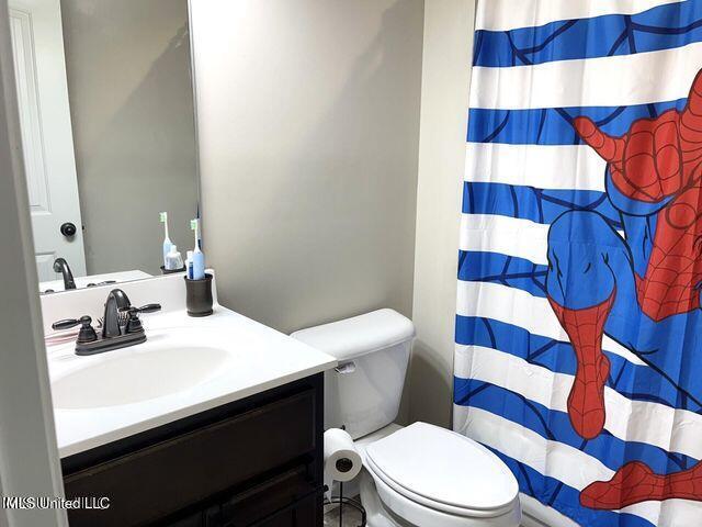 bathroom with toilet, a shower with curtain, and vanity