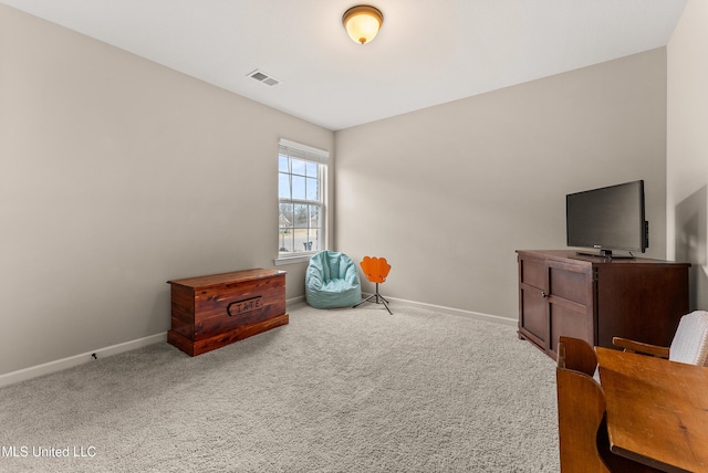 sitting room with carpet floors, visible vents, and baseboards