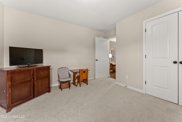 interior space featuring baseboards and light colored carpet