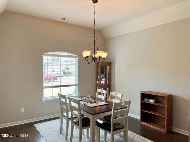 dining room featuring baseboards, vaulted ceiling, and dark wood-type flooring