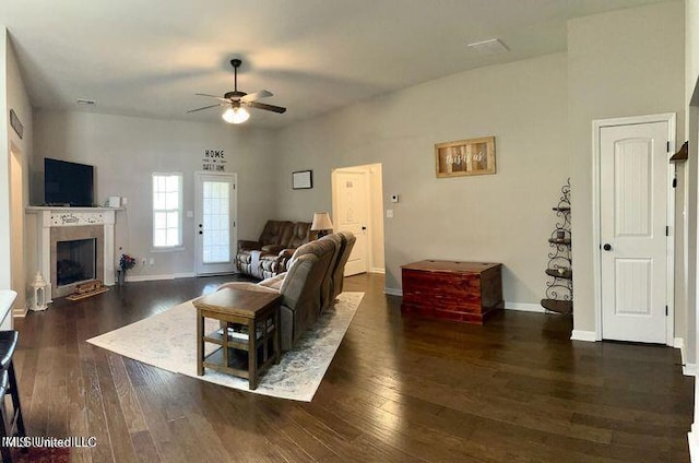 living room with a fireplace, visible vents, hardwood / wood-style floors, a ceiling fan, and baseboards