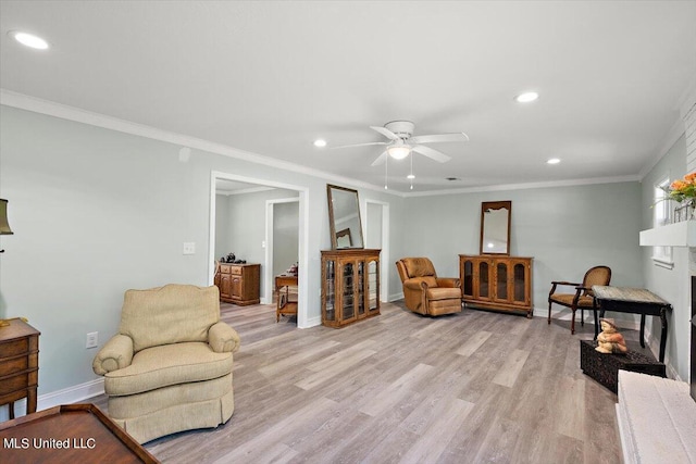 sitting room featuring light hardwood / wood-style floors, crown molding, and ceiling fan