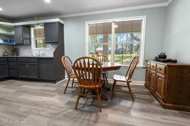 dining space with light hardwood / wood-style floors and ornamental molding