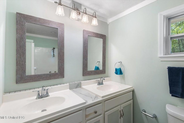 bathroom with vanity, crown molding, a textured ceiling, and toilet