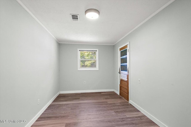 spare room with ornamental molding, a textured ceiling, and wood-type flooring