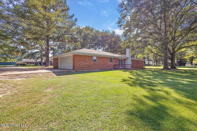 view of home's exterior with a deck, a yard, and a garage