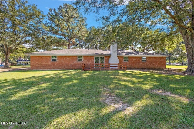 back of property with a yard and a deck