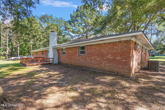 back of property with central air condition unit, a lawn, and a wooden deck