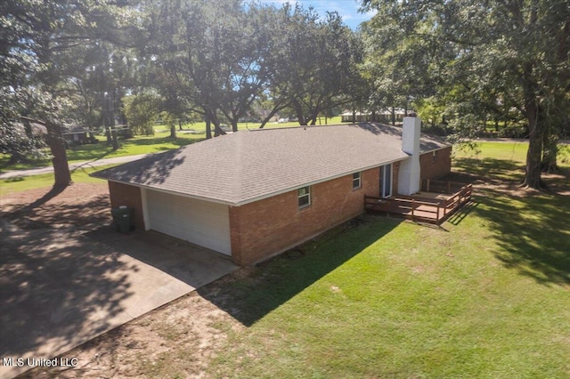 view of side of property with a garage and a lawn