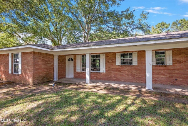 ranch-style home with a front yard and covered porch