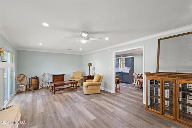 sitting room featuring ornamental molding, sink, wood-type flooring, and ceiling fan